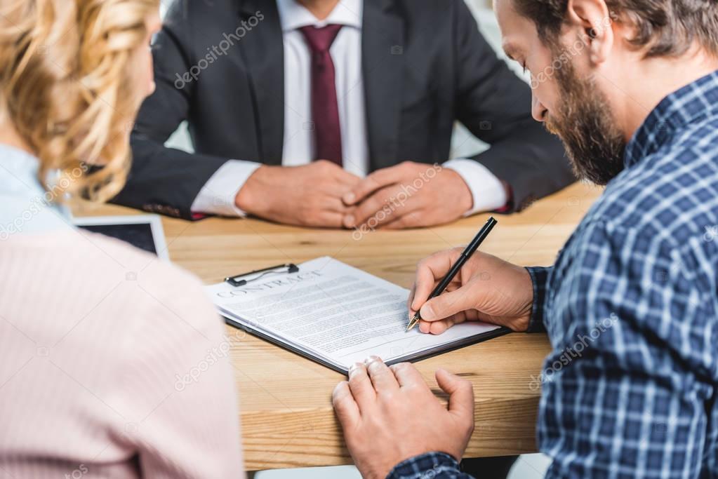 Gestor inmobiliario revisando y firmando un contrato de alquiler
